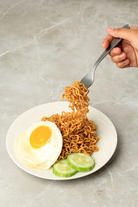 Eat fried noodle indomie goreng, take noodles with fork. copy space for text