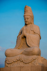 Low angle view of statue against clear blue sky