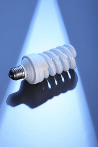 Close-up of energy efficient light bulb on blue table