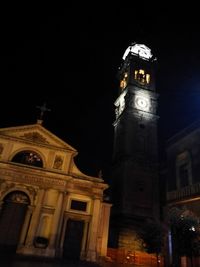 Low angle view of clock tower at night