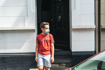 Full length of young man looking at camera with facial mask on