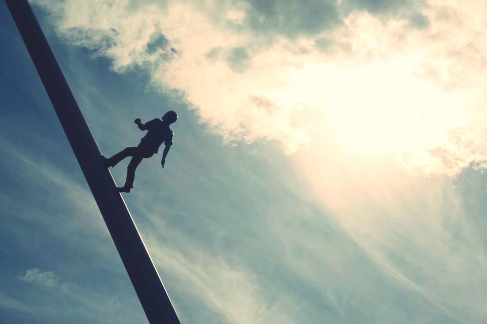 low angle view, sky, cloud - sky, silhouette, cloudy, cloud, sun, sunlight, sunbeam, day, outdoors, leisure activity, full length, mid-air, men, lifestyles, nature, jumping