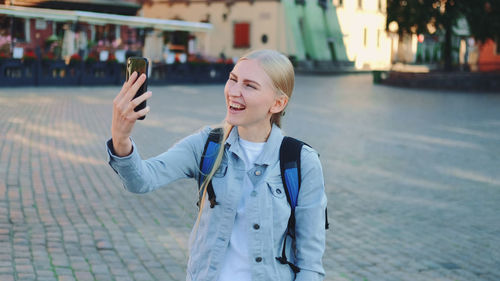 Young woman smiling while standing in city