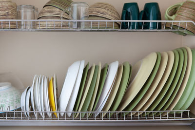 Clean dishes in white and green tones in a drying cabinet. cups, glasses, mugs, plates, bowls