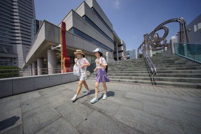 Rear view of man walking on sidewalk