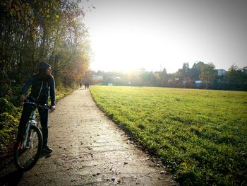 Rear view of person riding bicycle against sky