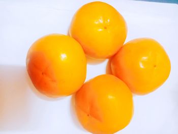 High angle view of orange eggs against white background