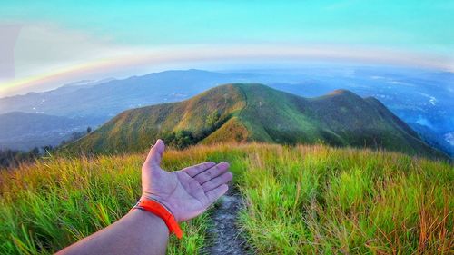 Person standing on mountain against sky