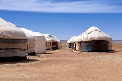 Abandoned building on field against clear blue sky