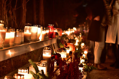 Illuminated tea light candles on shelves at night during halloween