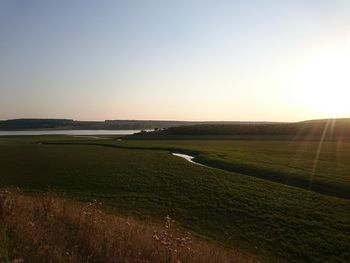 Scenic view of field against sky at sunset
