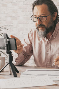 Side view of man using laptop while sitting on table