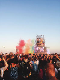 Crowd enjoying during festival in city against clear sky