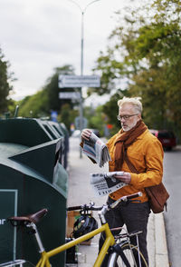 Man putting garbage into recycling bin