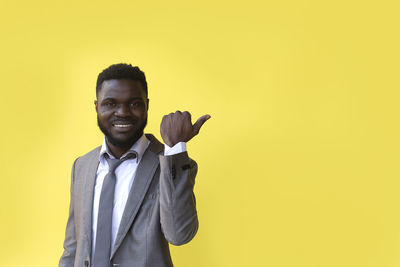Portrait of young man against yellow background