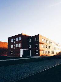 Building by river against clear sky