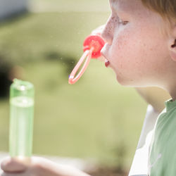 Close-up of boy blowing bubbles