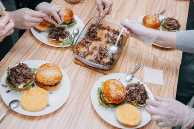 Burgers with beef and vegetables, the cooking process, hands collecting the burger.