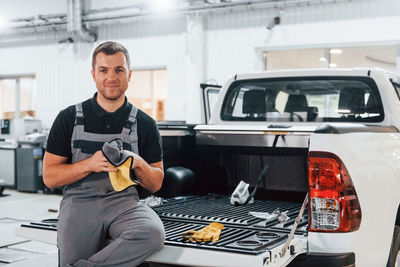 Portrait of young man using mobile phone while sitting in car