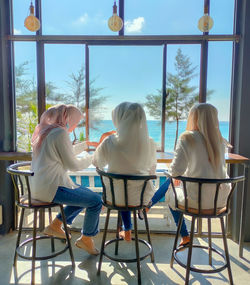 Rear view of people sitting on table