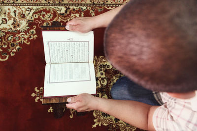 Directly above shot of man reading koran in mosque