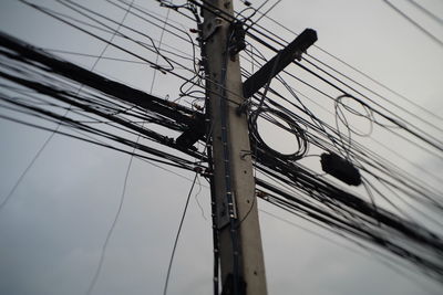 Low angle view of electricity pylon against sky