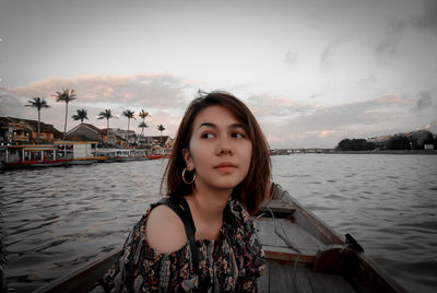 Portrait of beautiful woman in boat against sky