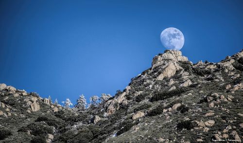 Low angle view of rocks against blue sky