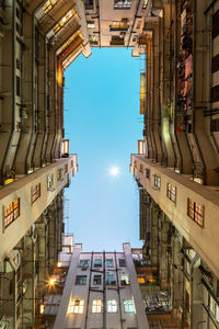 Low angle view of illuminated buildings against sky at dusk