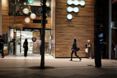 People walking on illuminated historic building