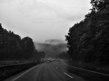 Road amidst trees against sky