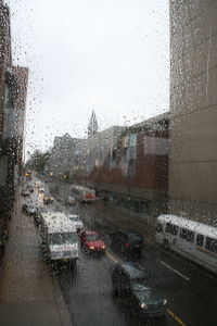 City seen through wet glass window during rainy season