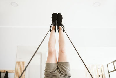 Man doing leg-up while practicing pilates in studio