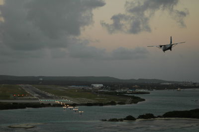 Airplane flying over sea against sky