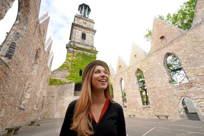 Young woman visiting the ruins of the church of aegidienkirche in hanover, germany