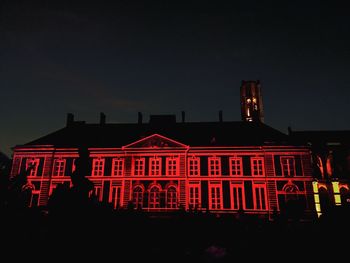 Red building against sky at night