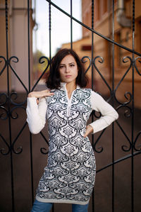 Portrait of young woman standing against wall