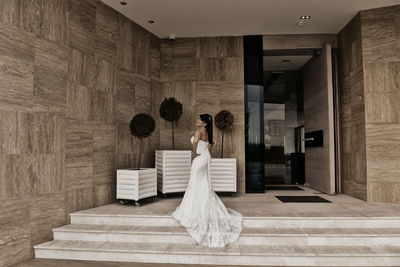 Rear view of woman walking in corridor of building