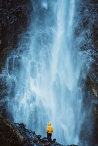 Person standing against waterfall