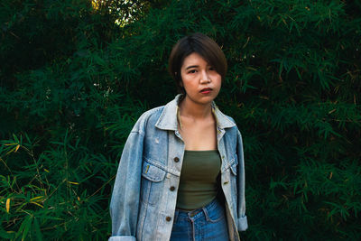 Portrait of beautiful young woman standing on land