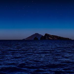 Scenic view of sea against blue sky at night