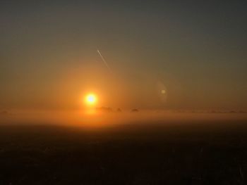 Scenic view of silhouette field against sky at sunset