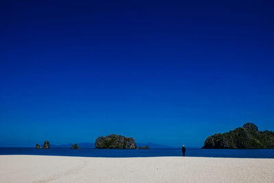 Scenic view of beach against clear blue sky