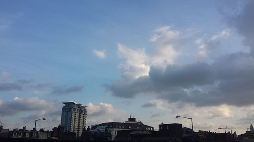 Low angle view of buildings against cloudy sky