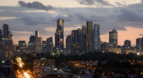 Illuminated buildings in city against sky