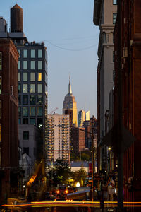 Illuminated buildings in city against sky