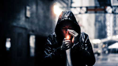 Man lighting cigarette with lighter during winter