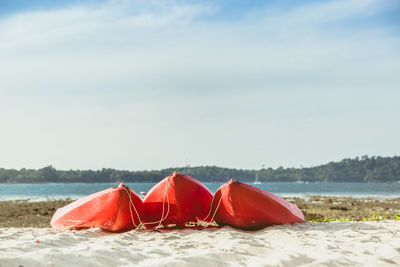 Red umbrella on beach against sky