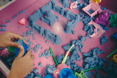 Cropped hand of person making castle by clay
