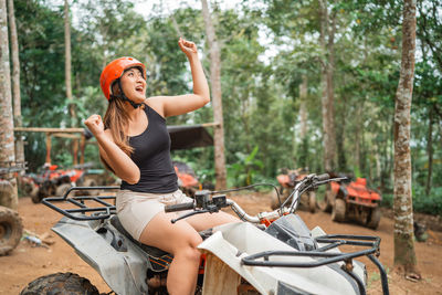 Side view of young woman riding bicycle